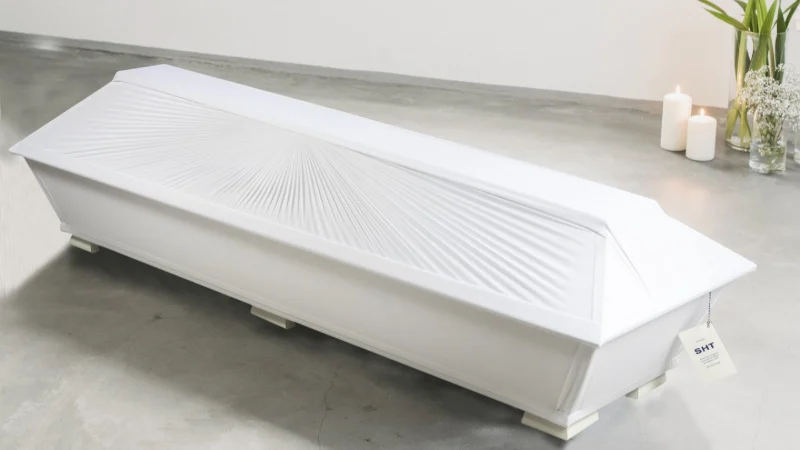 Auringonlasku arkku Puuvillaverhoiltu valkoinen hautausarkku, jonka kannen sädelaskostus laskeutuu tyylikkäästi koko pinnan yli – kotimainen, rauhallinen ja perinteikäs arkku valinta viimeiselle matkalle.